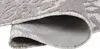 A close-up view of a rolled-up rug, showing the texture and underside. Produktbild-Vorschau