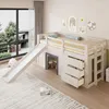 A child's loft bed with a slide, drawers, and a small play area underneath, set in a bedroom with a large window. Náhled obrázku produktu