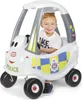 A child is sitting in a toy police car. Produktbild-Vorschau