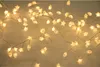 A close-up view of a string of warm white LED lights shaped like stars and leaves. Produktbild-Vorschau