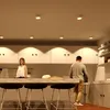A modern kitchen scene with two people standing at a counter. Produktbild-Vorschau