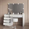 A white vanity table with LED lights and a stool, set against a light brown wall. Produktbild-Vorschau