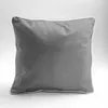 A gray pillow with a white trim is shown against a white and light gray background. Náhled obrázku produktu
