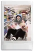 Two young women are having fun in a supermarket aisle, with one sitting in a shopping cart and the other pushing her. Produktbild-Vorschau