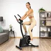 A woman is exercising on a stationary bike in a living room. Náhľad obrázku produktu