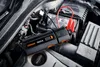A car battery jump starter is connected to a car battery in an engine bay. Náhled obrázku produktu