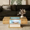 A modern living room scene featuring a coffee table with LED lighting. Produktbild-Vorschau