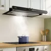 A modern kitchen scene with a black range hood above a stovetop where a blue pot is cooking. Náhľad obrázku produktu