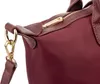 A close-up shot of a burgundy handbag, focusing on the zipper and strap attachment. Produktbild-Vorschau