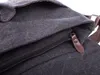 A close-up view of a dark gray canvas bag with a brown leather zipper pull. Podgląd zdjęcia produktu