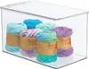 A clear plastic storage box filled with several balls of yarn in various colors. Produktbild-Vorschau
