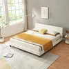 A bedroom scene with a white bed, yellow blanket, and a large window. Náhľad obrázku produktu