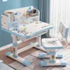 A child's desk and chair set with an astronaut theme, set up in a room with blue walls and curtains. Produktbild-Vorschau