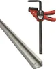 A clamp and a metal track are shown against a white background. Podgląd zdjęcia produktu