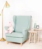 A mint green armchair with a pink unicorn plush toy on it, next to two small side tables with a vase and an alarm clock. Produktbild-Vorschau