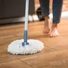 A person is mopping a wooden floor with a YORK Rotationsmop Spezial. Podgląd zdjęcia produktu
