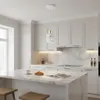 A modern kitchen with white cabinets, marble countertops, and a pendant light. Náhled obrázku produktu