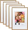 A stack of gold-colored picture frames with one frame displaying a close-up of a woman's face with colorful makeup and macarons. Produktbild-Vorschau