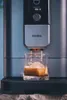 A coffee machine dispensing espresso into a glass. Produktbild-Vorschau