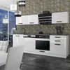 A modern, high-gloss white kitchen unit with a cityscape view through a large window. Produktbild-Vorschau