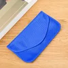 A blue signal blocking pouch is placed on a wooden surface next to a book. Produktbild-Vorschau