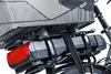 A close-up view of the rear of a bicycle, showing a black basket, a black battery pack secured with straps, and a red taillight. Náhľad obrázku produktu