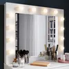 A vanity mirror with lights and makeup products on a dresser. Voir les images du produit