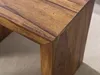 A close-up view of the corner of a wooden table. Voir les images du produit