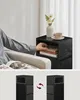 A person is reaching into a black nightstand to retrieve glasses, with a vase of flowers and a cup of coffee on top. Náhled obrázku produktu