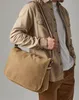 A person wearing a tan shirt and brown pants is carrying a tan messenger bag. Anteprima dell’immagine prodotto