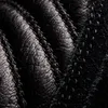 A close-up, textured view of black leather with stitching. Náhled obrázku produktu
