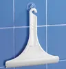 A white bathroom squeegee hanging on a blue tiled wall with a suction cup. Produktbild-Vorschau