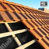 A close-up view of a roof under construction, showing terracotta tiles and underlayment. Produktbild-Vorschau