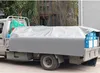 A truck bed covered with a gray tarp, with boxes visible underneath. Produktbild-Vorschau