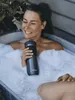 A woman is relaxing in a bubble bath outdoors, holding a Contigo travel mug. Anteprima dell’immagine prodotto