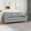 A light gray three-seater sofa is shown in a room with two framed pictures on the wall and a plant in the background. Produktbild-Vorschau
