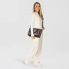 A woman is posing with a handbag. Produktbild-Vorschau