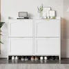 A white shoe cabinet with four flip-down doors, displaying shoes on the bottom shelf. Náhled obrázku produktu