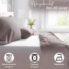 A bed with pillows and a duvet, with icons indicating care instructions. Produktbild-Vorschau