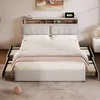 A bed with a headboard featuring storage and charging ports, set up in a bedroom with a rug and a nightstand. Anteprima dell’immagine prodotto