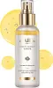 A bottle of d'Alba First Spray Serum is shown against a white background, with yellow liquid droplets surrounding it. Náhled obrázku produktu