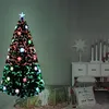 A decorated Christmas tree with gifts underneath, set in a room with furniture and decorations. Voir les images du produit