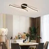 A modern dining room with a ceiling light, table, chairs, and decorative items. Voir les images du produit