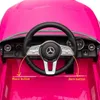 Close-up of the interior of a pink toy electric car, focusing on the steering wheel and dashboard. Produktbild-Vorschau