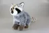 A plush toy raccoon sits on a plain light gray background. Produktbild-Vorschau