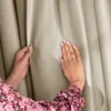 Hands touching a beige curtain. Produktbild-Vorschau