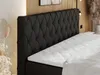 A close-up view of a black boxspring bed with a tufted headboard and a white mattress. Produktbild-Vorschau