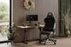 A gaming setup with a desk, chair, and computer in a room with wood-paneled walls and a window. Produktbild-Vorschau