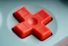 A close-up of a red directional button on a mint-colored controller. Produktbild-Vorschau
