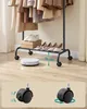 A clothing rack with clothes and shoes, and a robot vacuum cleaner below. There are also images of caster wheels at the bottom. Náhled obrázku produktu